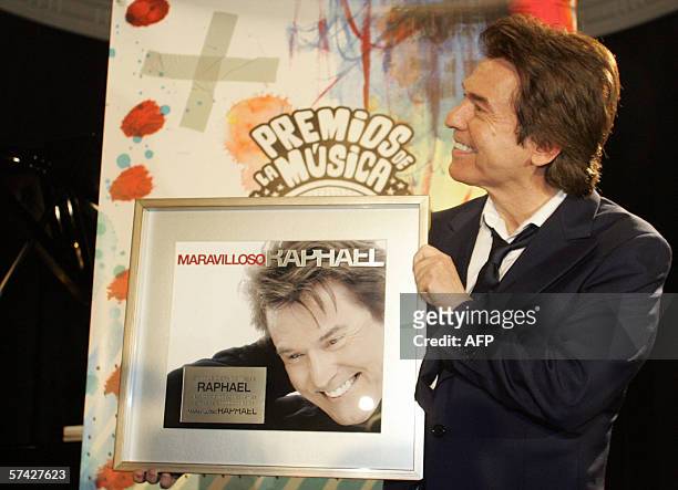 Spanish singer Raphael holds up a platinum copy of his recent album Marvilloso at a press conference to announce the start of a world tour in Madrid,...
