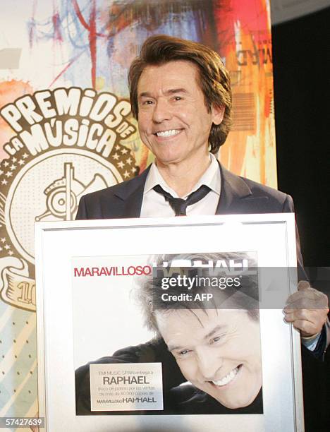 Spanish singer Raphael holds up a platinum copy of his recent album Marvilloso at a press conference to announce the start of a world tour in Madrid,...