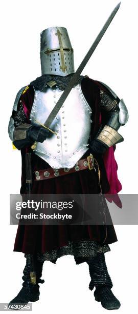 man wearing a armor suit holding a sword - armadura tradicional imagens e fotografias de stock