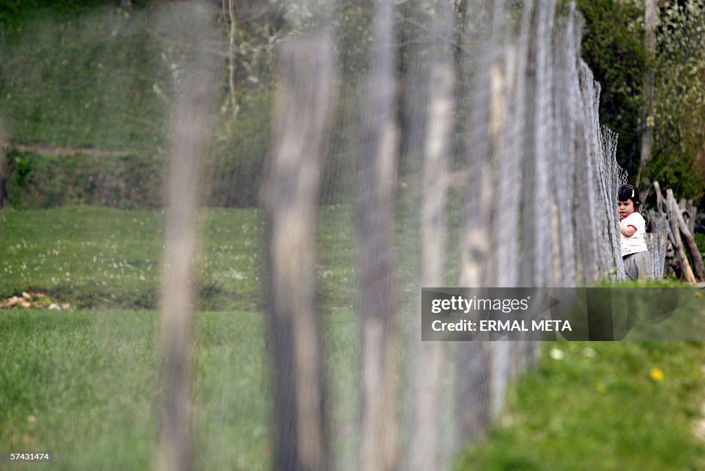 An ethnic Albanian girl stands at her fa