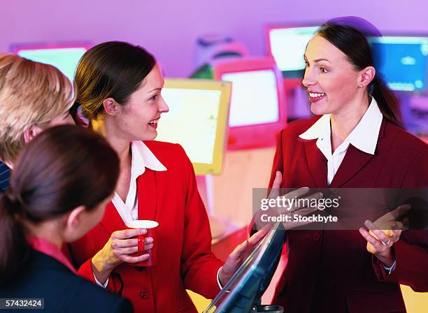 group of young businesswomen talking in the office - business woman in red suit jacket stock pictures, royalty-free photos & images