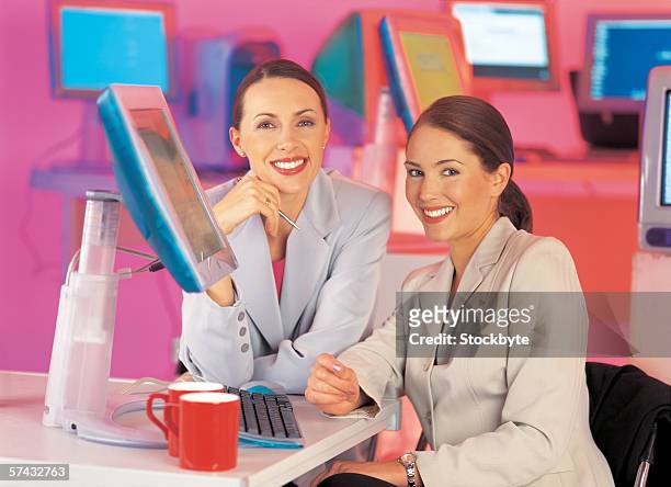 portrait of a businesswomen smiling and sitting together - business woman in red suit jacket stock pictures, royalty-free photos & images