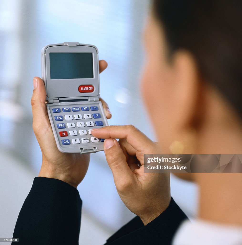 View of a woman using a calculator