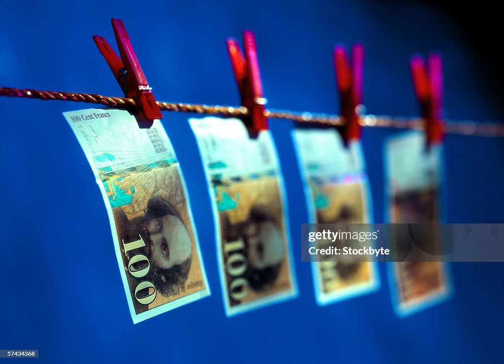 Close-up of currency hung from a clothesline