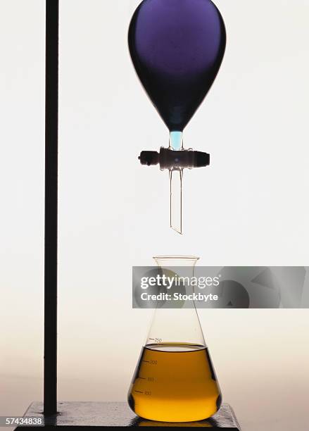 close-up of a flask kept under a pipette - lab flask imagens e fotografias de stock