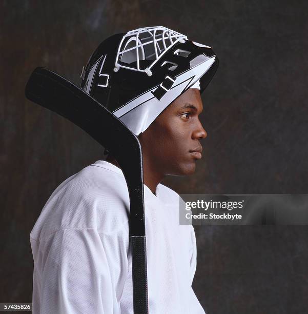 shot of a young male ice hockey player - hockey player black background stock pictures, royalty-free photos & images