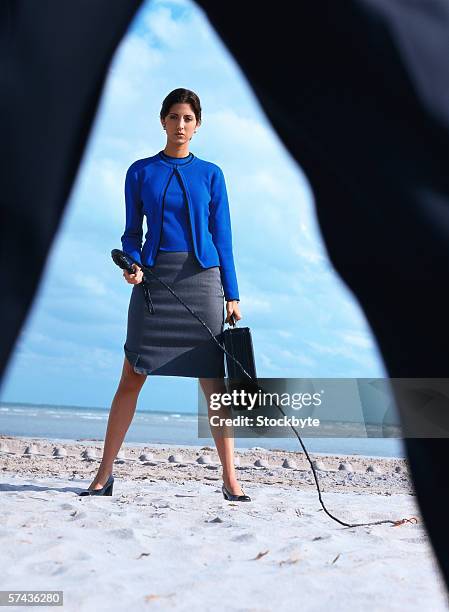 portrait of a business woman carrying a briefcase and holding a whip - blue skirt 個照片及圖片檔