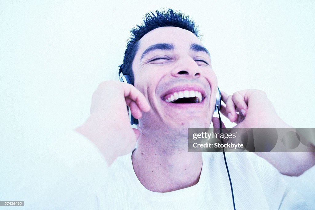 Tungsten view of a young man listening to music through headphones