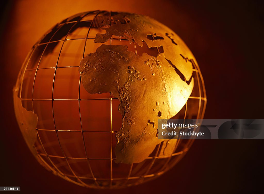 Sepia toned close-up of a mesh globe with patches of land