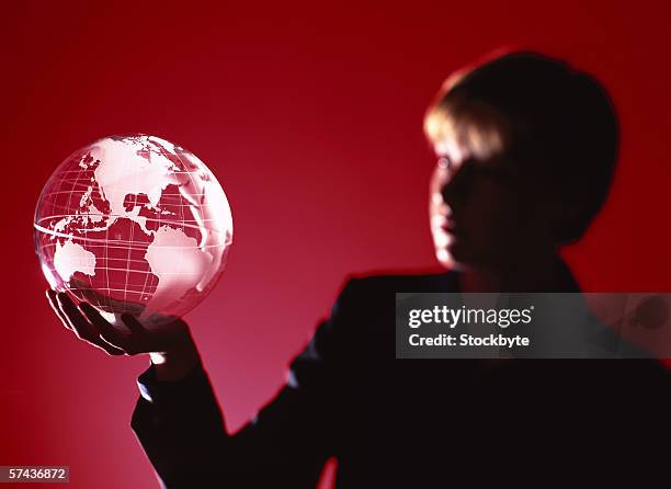 silhouette of a woman holding a glass globe on the palm - business woman in red suit jacket stock pictures, royalty-free photos & images