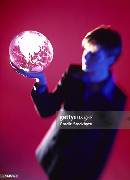 high angle view of a business woman holding a glass globe on the palm - business woman in red suit jacket stock pictures, royalty-free photos & images