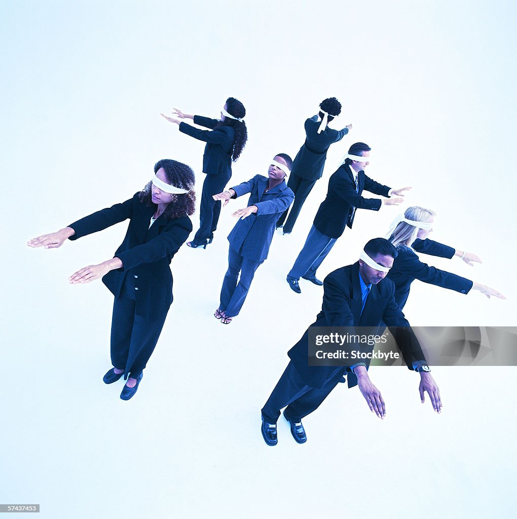 High angle view of blindfolded men and woman standing with arms outstretched