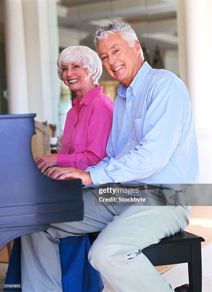 Side profile of a mature couple playing the piano together