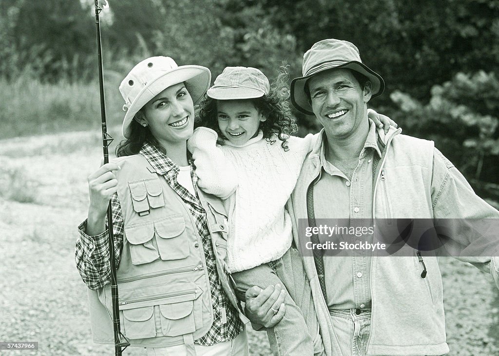 Black and white portrait of a mother and father on a fishing trip with their daughter