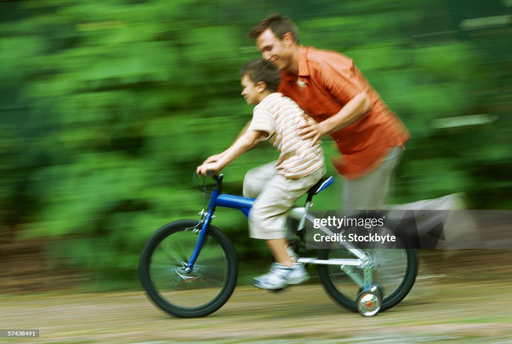 Father teaching his son how to ride a bike