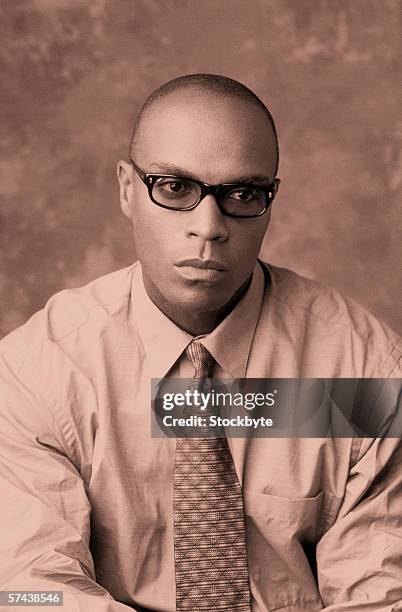 toned shot of a young man in a tie - portrait of pensive young businessman wearing glasses stock pictures, royalty-free photos & images