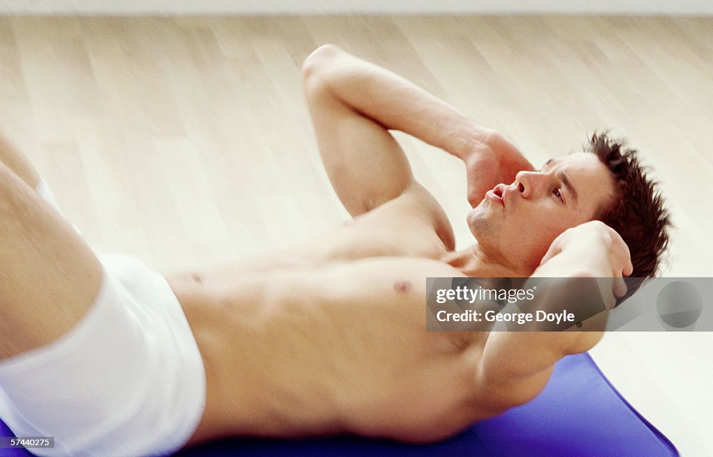 A young man exercising on a exercise mat