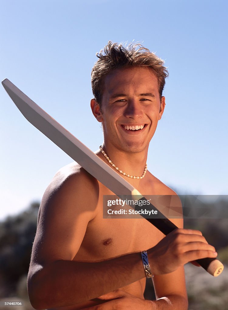 Portrait of a young man holding a cricket bat on his shoulder