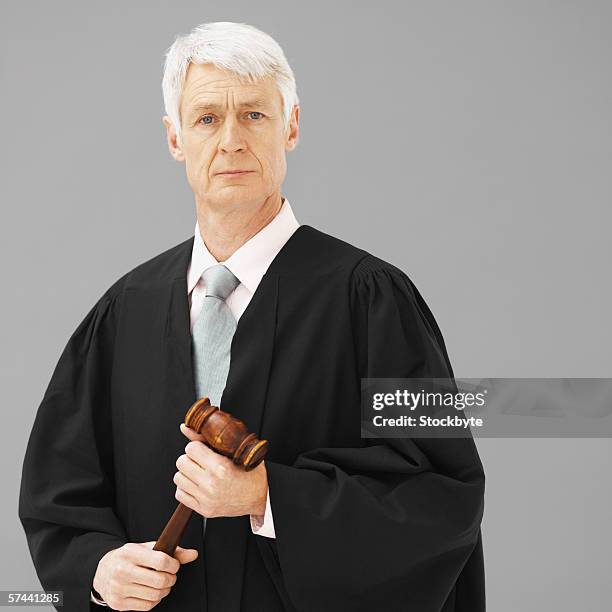 portrait of a male judge, holding a gavel - judge gavel stock pictures, royalty-free photos & images
