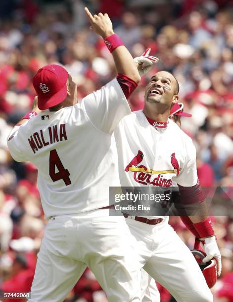 Albert Pujols and Yadier Molina of the St. Louis Cardinals celebrate after Pujols drove in the game-winning run with an RBI single in the bottom of...