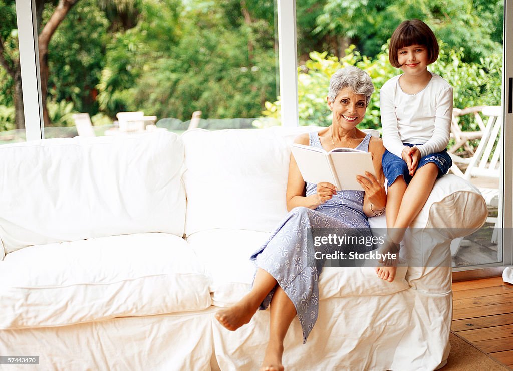View of an elderly woman reading with her granddaughter