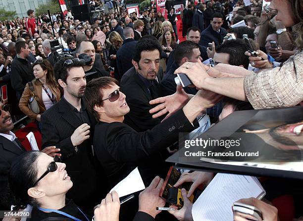 American actor Tom Cruise greets fans after arriving at the "Mission: Impossible III" French Premiere on April 26, 2006 in La Defense, outside Paris,...