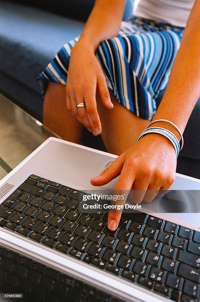 Close-up of a woman's finger on a laptop computer keyboard