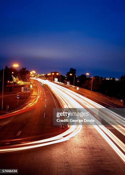 high angle time lapse view of traffic on a city street at night - traffic time lapse stock pictures, royalty-free photos & images