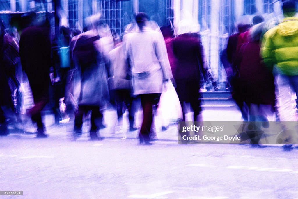 Blurred view from behind of pedestrians walking across a street