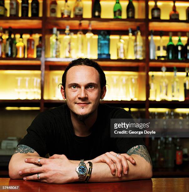 portrait of a bartender standing behind the bar counter - bar man t shirt ストックフォトと画像
