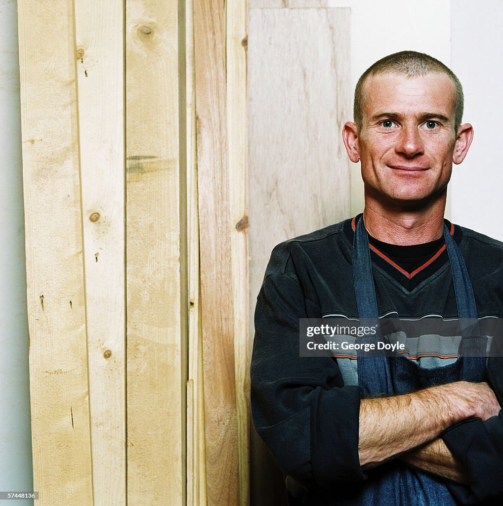 Portrait of a carpenter standing with wooden planks