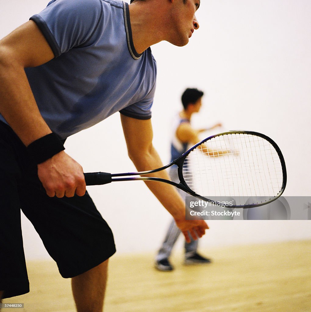 Low angle side view of a man playing tennis outdoors