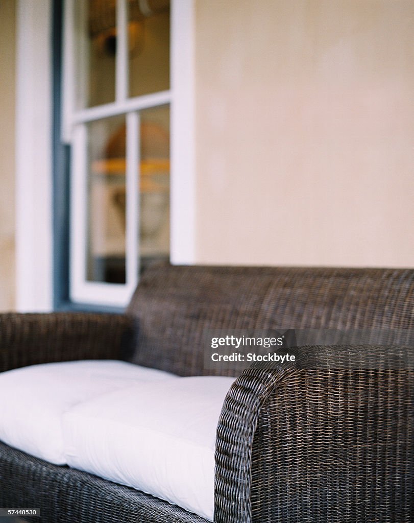 Close-up of a wicker couch with white cushions