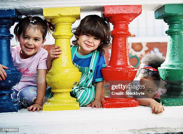 group of young children (4-6) looking through banisters smiling - 3 säulen stock-fotos und bilder