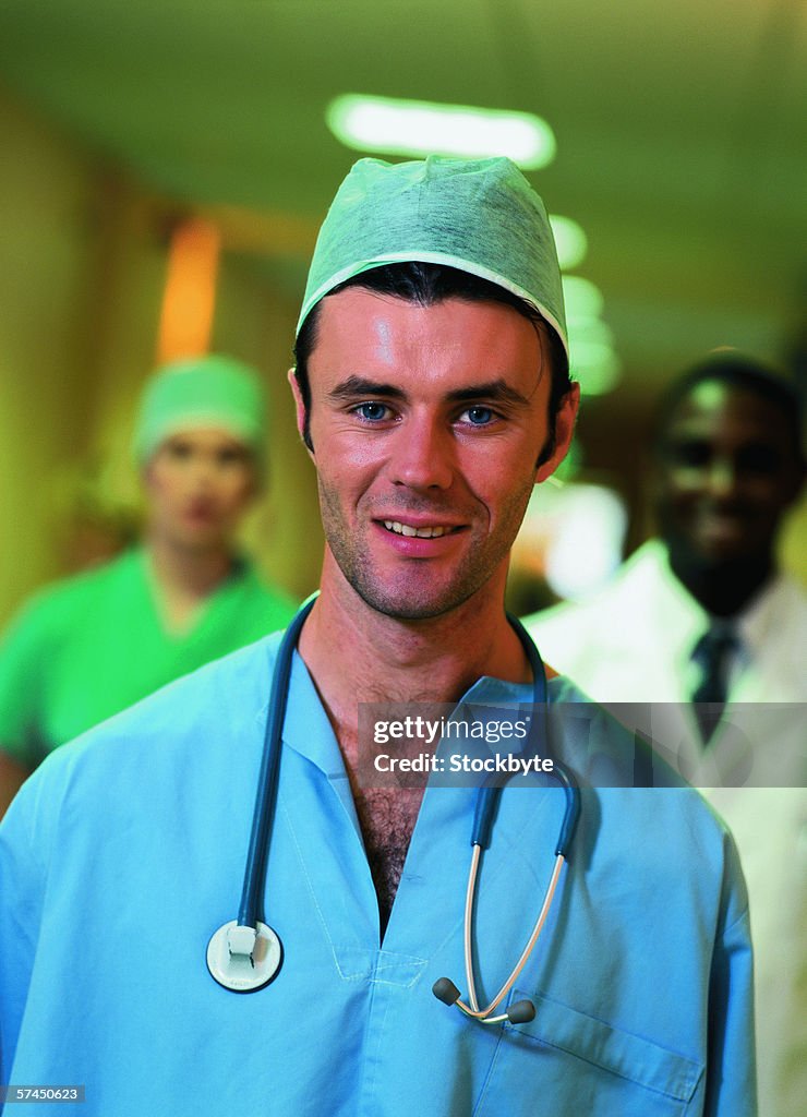 Portrait of a male doctor and medical staff standing in a hospital corridor