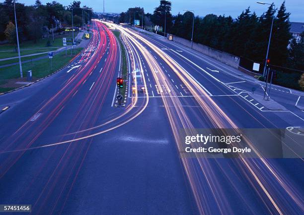 time lapse view of traffic on a city street at twilight - traffic time lapse stock pictures, royalty-free photos & images