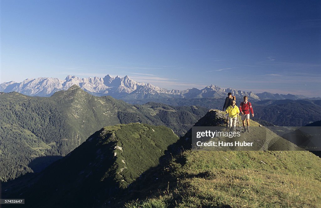 Austria, Salzburger Land, three people hiking in alps