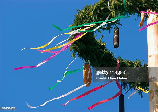 austria, maypole wreath with pretzel and sausage, low angle view - maibaum stock-fotos und bilder