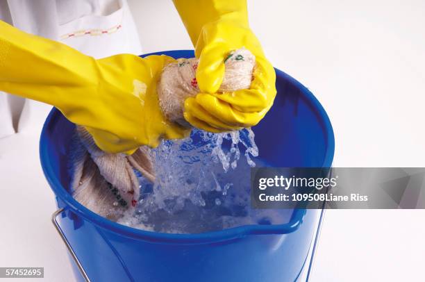 woman wringing out cleaning rag, elevated view - straccio foto e immagini stock