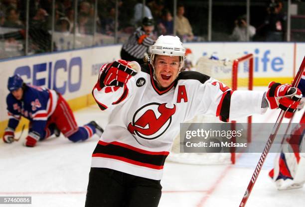 Patrik Elias of the New Jersey Devils celebrates a goal by teammate Jamie Langenbrunner as Sandis Ozolinsh of the New York Rangers falls to the ice...