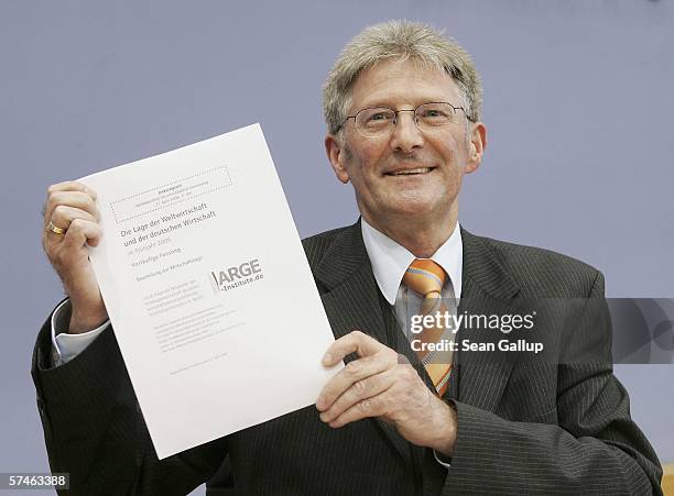 Eckhardt Wohlers of HWWA economic research institute holds up the report on the state of the world and German economies in spring, 2006 according to...
