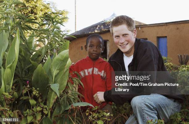 Prince Harry with old friend Mutsu Potsane, inspect the Peach Tree that they planted in the grounds of the Mants'ase childrens home in March 2004,...