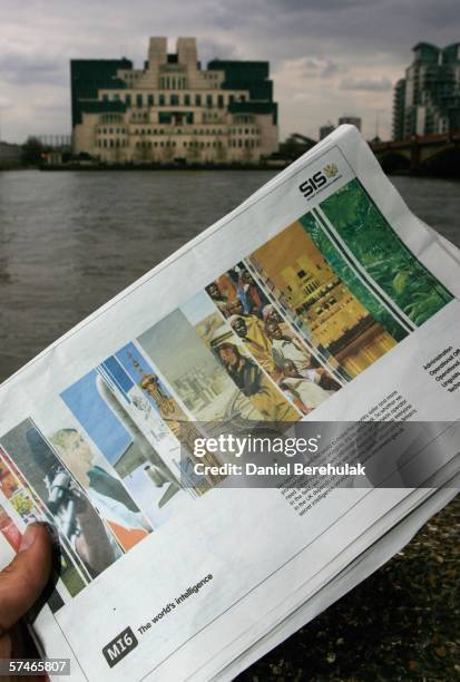 In this photo illustration a newspaper shows an advertisement seeking new MI6 employees as the MI6 headquarters stands in the backround on April 27,...