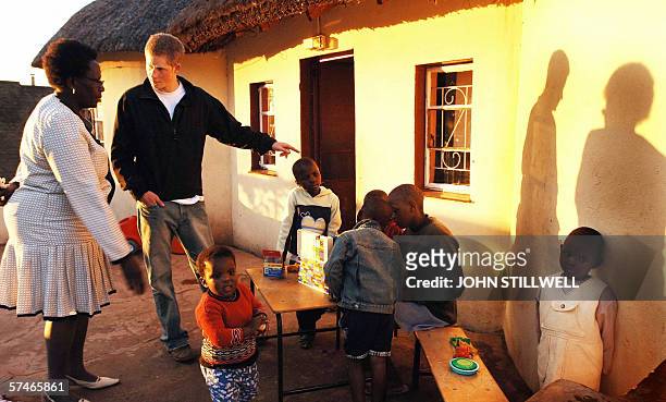 Prince Harry listens to Lydia Muso of the Lesotho children's counsellling unit near to the capital of Maseru,while on a return visit to Lesotho in...