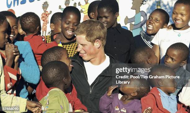 Prince Harry plays with Mutsu Potsane and other children in the grounds of the Mants'ase children's home during a return visit to Lesotho in southern...