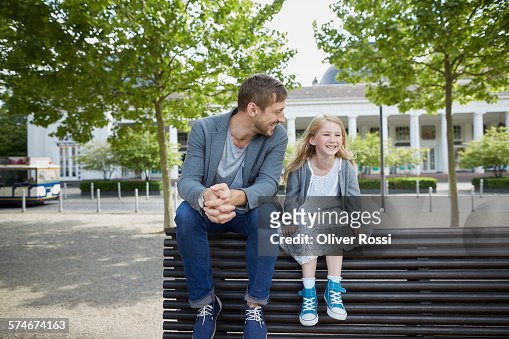 Smiling father and daughter on bench
