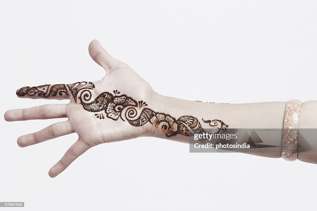 Close-up of a young woman with henna tattoo's on her hand