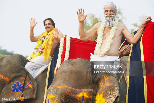 portrait of two priests riding elephants - hindu segenszeichen stock-fotos und bilder