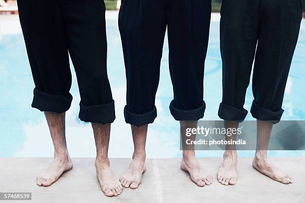 high angle view of three pairs of legs - rolled up trousers stock-fotos und bilder