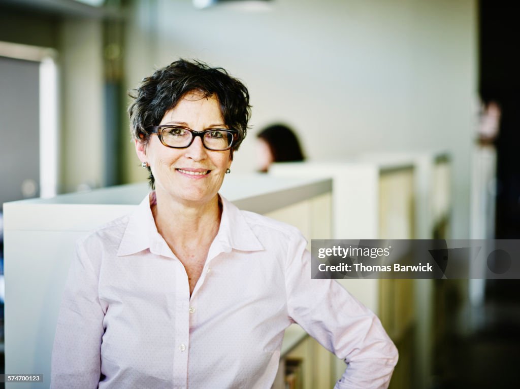 Smiling female business owner standing in office